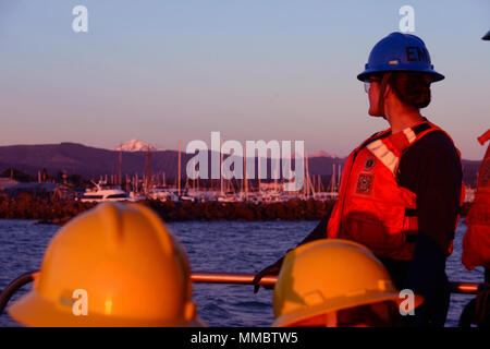 Coast Guard Petty Officer 2nd class Kelly Yost, Gehilfen an Aids zur Navigation Puget Sound stationiert ist ein Elektriker, bewundert die Aussicht während der Fahrt mit Ihrer Crew in Bellingham, Washington, August 16, 2016. Heute, die Küstenwache, baut, unterhält und betreibt rund 49.700 visuelle Hilfsmittel zur Navigation, die die Bemühungen von 2.564 Soldaten auf 76 Fräser zugewiesen, 61 Aids zur Navigation Teams und vier kleinen Boot Stationen mit Navigationshilfen Verantwortlichkeiten. Us-Küstenwache Stockfoto