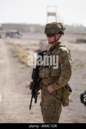 Eine australische Armee Soldat, eingesetzt zur Unterstützung der Combined Joint Task Force - Betrieb Zugehörig zu lösen, bietet Schutz bei Treffsicherheit Training mit Mitglieder der irakischen Sicherheitskräfte in Camp Taji, Irak, Sept. 28, 2017. Camp Taji ist einer von vier Combined Joint Task Force - inhärenten Building Partner Kapazität beheben Standorte Ausbildung Partner Kräfte und Verstärkung ihrer Wirksamkeit auf dem Schlachtfeld gewidmet. CJTF-OIR ist die globale Koalition zu besiegen ISIS im Irak und in Syrien. (U.S. Armee Foto von Cpl. Rachel Diehm) Stockfoto