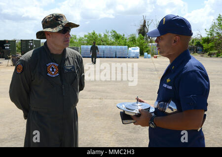 Us Marine Corps Oberstleutnant Doug Thumm, der kommandierende Offizier der Marine Medium Tiltroter Squadron 264, Gespräche mit der U.S. Coast Guard lt Francisco Muniz Valle, der Kaplan der Coast Guard Air Station Borinquen, Puerto Rico, an Rafael Hernandez Flughafen Aguadilla, Puerto Rico, 8. Oktober, 2017. Muniz Valle zur religiösen Betreuung und Beratung der Marinesoldaten und Matrosen von VMM-264, nach Puerto Rico für Hurrikan Maria die Reaktion und die Wiederherstellung ein Bemühungen von ihrem Haus in der Marine Corps Air Station New River, N.C.U.S. bereitgestellt Coast Guard Foto von Senior Chief Petty Officer Kyle Niemi Stockfoto