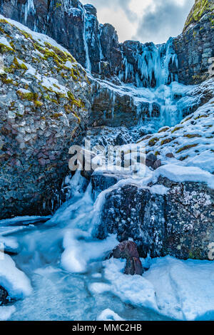 Wasserfall im Schnee mit interessanten Basalt Felsen östlich von Olafsvik, Snaefellsnes, West Island Stockfoto