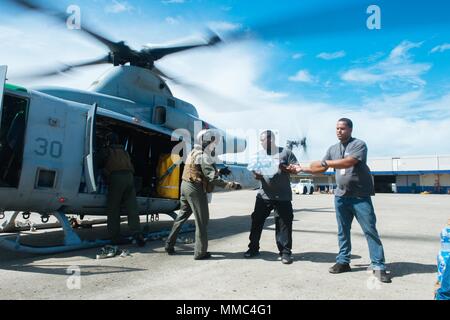 171006-N-IM-651-130 PUERTO RICO (Okt. 2010) 6, 2017) - Federal Emergency Management Agency Personal und US-Marines last Wasser in eine UH-1 Huey, zum VMM-161 während Remote Nahrung und Wasser Verkehr zugeordnet. Das Verteidigungsministerium ist die Unterstützung der Federal Emergency Management Agency, die federführende Bundesbehörde, dabei helfen, die Betroffenen durch den Hurrikan Maria Leiden zu minimieren und als ein Bestandteil des gesamten-von-Reaktion seitens der Regierung Bemühungen. (U.S. Marine Foto von Gunners Mate 1. Klasse Jonathan Eddy/freigegeben) Stockfoto