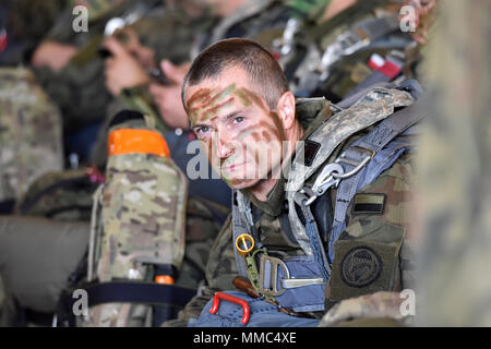 Eine polnische Fallschirmjäger wartet eine polnische Luftwaffe C-130 Hercules Platine von 33 ATB in Aviano Air Base, in Pordenone, Italien Oktober 10, 2017 in der Vorbereitung für Airborne Operations auf Hohenburg Drop Zone, Deutschland während der Übung schnelle Antwort 2017. Schnelle Antwort Links zu Übung Sabre Guardian 17, ein US Army Europe-led, multinationale Übung, erstreckt sich über Bulgarien, Ungarn und Rumänien mit mehr als 25.000 service Mitglieder aus 22 NATO-Mitglieder und der Partnerstaaten. (U.S. Armee Fotos von visuellen Informationen Spezialist Paolo Bovo/Freigegeben) Stockfoto