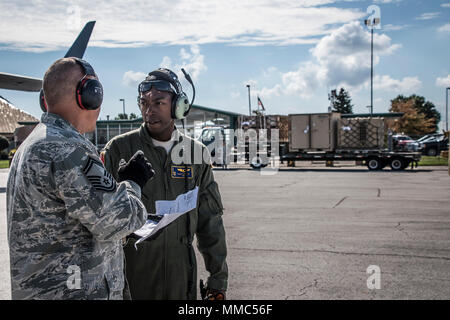 Senior Airman Thomas Bennett ein lademeister mit der 105 Airlift Wing (AW) spricht mit Senior Master Sgt. Tschad Shifflet über den Ladeplan für die C-17 der 105 AW auf der 179th Airlift Wing in Mansfield, Ohio, 10. Oktober 2017 übermittelt. Der 105 AW schickte eine C-17 bis zu den zweiten Katastrophenhilfe Beddown System (Drbs), der 200 RED HORSE Squadron (RHS) gesandt hat im Hurrikan Hilfsmaßnahmen zu erleichtern. Diese zweite Drbs in Puerto Rico. Mit der einzigartigen Fähigkeiten und Vermögen der 200 RHS hat als autarke Einheit, die überall in der Welt innerhalb von 72 Stunden bereitstellen können, die u Stockfoto