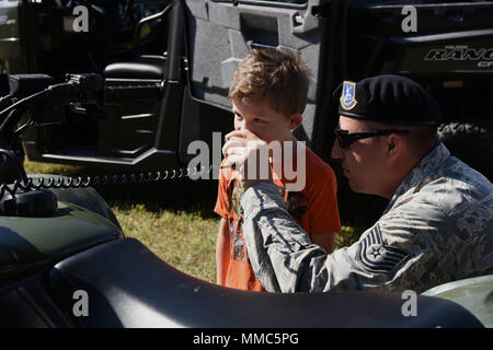 Tech. Sgt. Jared Miller, 81st Security Forces Squadron Einheit Abteilungsleiter, lässt Ean Töpfer, Sohn des Airman 1st Class James Töpfer, 334 Training Squadron student, sprechen, in ein Land Mobile Radio während einer Exkursion in die 81St SFS für Home Kinder Sept. 29, 2017 geschult, auf Keesler Air Force Base, Texas. Der 81st SFS eine militärische Gebrauchshund Leistung, eine Waffen Sicherheit Demonstration und eine Tour durch ihre Patrouille Fahrzeugen. (U.S. Air Force Foto von Kemberly Groue) Stockfoto