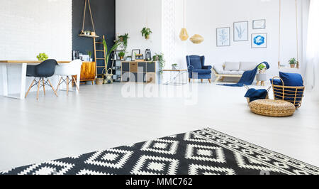 Moderne, helle Wohnung mit Wohnzimmer, schwarze Wand und Teppich Stockfoto