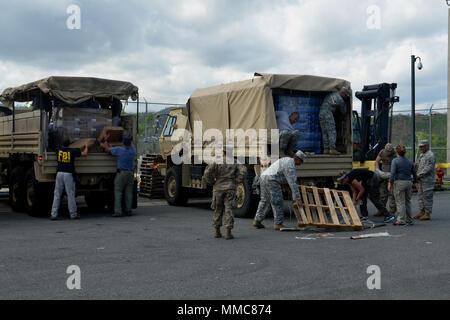 FBI-Agenten und US Army Reserve Soldaten, 393 Bekämpfung Sustainment Support Bataillons, 166 Region Support Group, 1. Mission unterstützt den Befehl, militärische Fahrzeuge mit Wasser, Nahrungsmitteln und tarps in San Juan, Puerto Rico, Oktober 11, 2017, zu den Bewohnern in abgelegenen Gebieten von Adjuntas verteilt werden. Regierungsbehörden Bemühungen, Katastrophenhilfe in Puerto Rico zur Verfügung zu stellen nach dem Hurrikan Maria katastrophale Schäden verursacht. (U.S. Armee Foto: Staff Sgt. Elvis) Stockfoto