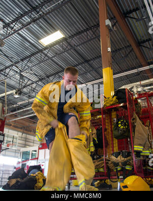 Ein Feuerwehrmann aus dem 60. Bauingenieur Squadron Feuerwehr- und Rettungsdienste Flug, zieht sich seine Wildland persönliche Schutzausrüstung bei Travis Air Force Base, Calif., Okt. 11, 2017. Auf Antrag der zivilen Behörden, Travis Personal und Ausrüstung unterstützen Kollegen Ersthelfer Schlacht lokale wildfires, das Brennen in den Counties Napa Valley, Sonoma und Solano, Calif., seit Okt 8. (U.S. Air Force Foto von Louis Briscese) Stockfoto