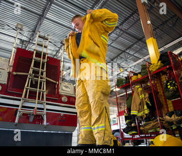 Ein Feuerwehrmann aus dem 60. Bauingenieur Squadron Feuerwehr- und Rettungsdienste Flug, zieht sich seine Wildland persönliche Schutzausrüstung bei Travis Air Force Base, Calif., Okt. 11, 2017. Auf Antrag der zivilen Behörden, Travis Personal und Ausrüstung unterstützen Kollegen Ersthelfer Schlacht lokale wildfires, das Brennen in den Counties Napa Valley, Sonoma und Solano, Calif., seit Okt 8. (U.S. Air Force Foto von Louis Briscese) Stockfoto