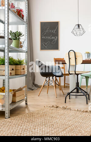 Wohnung im industriellen Stil mit Tisch, Stühlen und einfache Regale Stockfoto