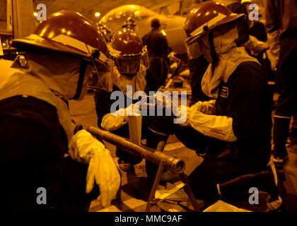 ARABIAN GULF (Okt. 2010) 10, 2017) U.S. Navy Segler in Rohr patching Ausbildung während eines damage control Bohren an Bord der Flugzeugträger USS Nimitz (CVN 68), Oktober 10, 2017, in den Arabischen Golf teilnehmen. Der Nimitz ist in den USA der 5. Flotte Bereich der Operationen zur Unterstützung der Operation inhärenten Lösung bereitgestellt. Während in dieser Region, das Schiff und Streik Gruppe leiten Maritime Security Operations Verbündeten und Partnern zu beruhigen, die Freiheit der Schifffahrt zu bewahren und den freien Fluss des Handels halten. (U.S. Marine Foto von Mass Communication Specialist 3. Klasse Leon Wong) Stockfoto