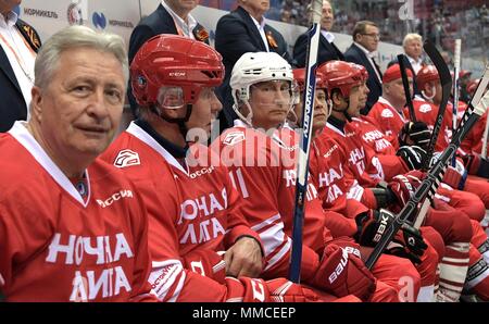 Sochi, Russland. 10. Mai, 2018. Der russische Präsident Wladimir Putin, Mitte, auf der Bank mit Mannschaftskameraden Liga Präsident Alexander Yakushev, Links, und des Ersten Stellvertretenden Vorsitzenden der Staatsduma Ausschuss für körperliche Fitness, Tourismus und Jugend, Vyacheslav Fetisov, 2. links, während der Nacht Hockey League Spiel in der 7. russischen laienhaften Ice Hockey Festival im Bolschoj Ice Dome am 10. Mai 2018 in Sotschi, Russland. (Russische Vorsitz über Planetpix) Credit: Planetpix/Alamy leben Nachrichten Stockfoto