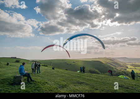 Brighton, Sussex, UK..10. Mai 2018..Kühleres Wetter, Wolken & Nordwestwind bringt Gleitschirmflieger zu Devils Dyke auf dem South Downs Way. Stockfoto