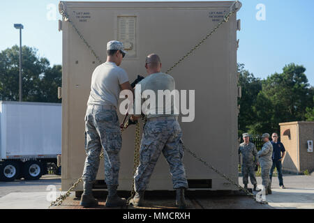 Senior Airman Christian Bonenberger, 85 Engineering Installation Squadron material Control Manager und Personal Sgt. Victor Mancaruso, 85 EIS Fahrer, Secure Cargo Container für eine Bereitstellung von Puerto Rico an der 85 EIS Fahrzeug Betriebsgebäude am Keesler Air Force Base, Texas zu unterstützen. In der von Hurrikan Maria, land Mobilfunk Puerto Rico's Infrastruktur für Ersthelfer sind in der entsetzlichen Notwendigkeit der Reparatur und der 85 EIS mit Namen gebeten, ihn wieder hoch zu helfen. (U.S. Air Force Foto von älteren Flieger Travis Beihl) Stockfoto