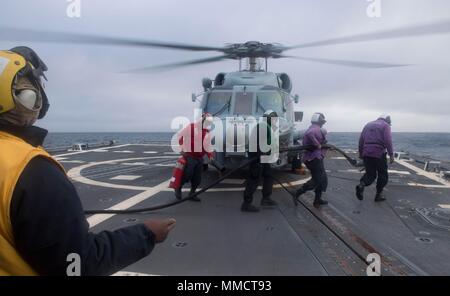 171007-N-IC 246-0110 IRISCHE SEE (Okt. 2010) 7, 2017) Matrosen an Bord der Arleigh-Burke-Klasse geführte-missile Destroyer USS Winston S. Churchill (DDG81) führen Sie eine Hot Tanken auf einem MH-60R Sea Hawk Hubschrauber während der Übung gemeinsame Krieger 17-2, Oktober 7, 2017. Gemeinsame Krieger ist ein UK-led, multinationale Übung, die Interoperabilität und die Zusammenarbeit in allen Bereichen anwendbar Kriegsführung entwickelt. (U.S. Marine Foto von Mass Communication Specialist Seaman Apprentice Raymond Maddocks/Freigegeben) Stockfoto