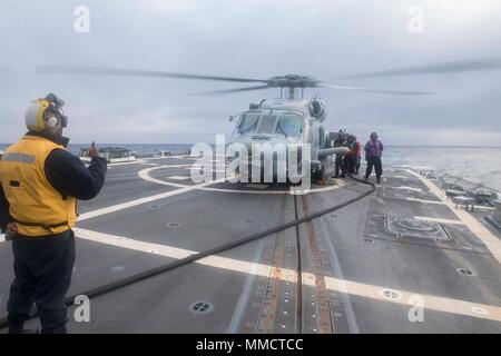 171007-N-IC 246-0136 Irische See (Okt. 2010) 7, 2017) Matrosen an Bord der Arleigh-Burke-Klasse geführte-missile Destroyer USS Winston S. Churchill (DDG81) führen Sie eine Hot Tanken auf einem MH-60R Sea Hawk Hubschrauber während der Übung gemeinsame Krieger 17-2, Oktober 7, 2017. Gemeinsame Krieger ist ein UK-led, multinationale Übung, die Interoperabilität und die Zusammenarbeit in allen Bereichen anwendbar Kriegsführung entwickelt. (U.S. Marine Foto von Mass Communication Specialist Seaman Apprentice Raymond Maddocks/Freigegeben) Stockfoto