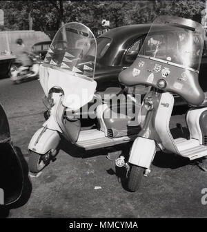 1960s, zwei Motorroller mit Verkleidungen, Lambrettas aus Italien, geparkt in einer Straße in London, England, Großbritannien. Die Lambretta 1501d hat sowohl RAC- als auch AA-Abzeichen und Aufkleber auf der Verkleidung, was darauf hindeutet, dass sie gut für Auslandsreisen verwendet wurde. Stockfoto