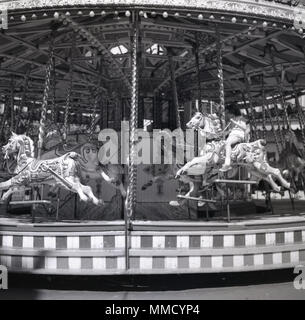 1960, historische, junges Mädchen, ein hölzernes Pferd auf einem Karussell oder Merry-go-round im Fun Fair an der Battersea Park, London, England, UK. Die Messe war für das Festival 1951 von Großbritannien feiern, die in den nördlichen Teil des Parks gebaut und war einer der wichtigsten Attraktionen für viele Jahre. Stockfoto