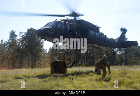 Army Staff Sgt. Troy Debro eines Unternehmens, 230ste Brigade Support Bataillon, 30 gepanzerte Brigade Combat Team, North Carolina National Guard, verlässt eine Landing Zone nach dem Anspannen einer Schlinge laden zu einem UH-60 Blackhawk von Mitgliedern des C Unternehmen 1-131 Aviation vorgesteuert, Theater 449th Aviation Brigade, NCNG, Bohrer in Fort Bragg, N.C., am Okt. 14, 2017. Stockfoto