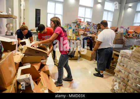 Caguas Stadt Mitarbeiter und freiwillige Arbeit bei der caguas Punkt der Verteilung von Nahrungsmitteln, Wasser und andere Hilfsgüter zur Verteilung an die Betroffenen durch den Hurrikan Maria, Oktober 16, 2017, Caguas Puerto Rico zu organisieren. Die Federal Emergency Management Agency und seiner föderalen Partner weiterhin 24-Stunden-Betrieb Missionen zur Unterstützung der Betroffenen durch den Hurrikan Maria zu führen. (U.S. Air Force Foto von Master Sgt. Joshua L. DeMotts) Stockfoto