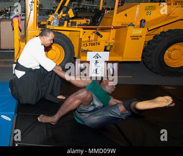 171012-N-SA 412-0148 karibische Meer (Okt. 2010) 12, 2017) Leutnant Keith Braddy (links) zeigt eine auf dem Schiff Veteran 1. Klasse Aderson Jeanfrancois während ein Aikido, Klasse im Hangar Bucht der Amphibisches Schiff USS Wasp werfen (LHD1). Aikido ist eine japanische Kampfkunst, die gemeinsame Schlösser und wirft einen Gegner Energie umzuleiten. Wasp wird derzeit durch die Karibik für humanitäre Hilfsmaßnahmen in den von Hurrikan Maria. (U.S. Marine Foto von Mass Communication Specialist 3. Klasse Sean Galbreath / freigegeben) Stockfoto