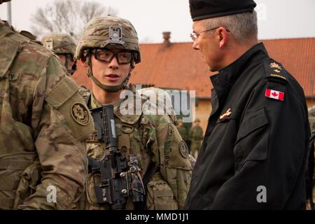 Ein US-Soldat in die Schlacht Gruppe Polen zugewiesen spricht an einen kanadischen Offizier 17. Okt. 2017 Bemowo Piskie, Orzysz, Polen. Eine Gruppe von Delegierten aus verschiedenen Ländern besuchen Sie die US-Battle Group einschließlich Rumänisch, Kroatisch und britischer Soldaten, deren Verteidigung und Abschreckung Mission zur Unterstützung des NATO-enhanced Vorwärts Präsenz Initiative geführt. Stockfoto