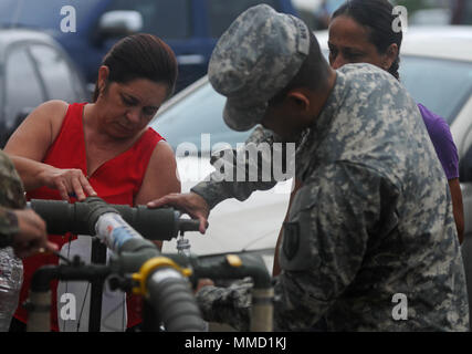 Citizen-Soldiers mit der 714Th Quartermaster Firma, 191St Region Support Group, von der Puerto Rico National Guard verteilt Wasser in die Gemeinschaft von Barahona in der Gemeinde Morovis, Puerto Rico, Okt. 16. Die Gardisten kam mit zwei Fahrzeugen, die jeweils 2.000 Gallonen gereinigtes Wasser. (Fotos von SPC. Agustín Montañez, PRNG-PAO/Freigegeben) Stockfoto