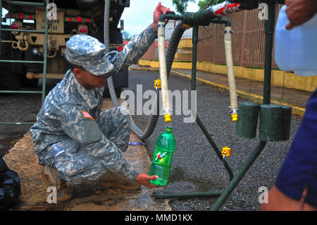 Citizen-Soldiers mit der 714Th Quartermaster Firma, 191St Region Support Group, von der Puerto Rico National Guard verteilt Wasser in die Gemeinschaft von Barahona in der Gemeinde Morovis, Puerto Rico, Okt. 16. Die Gardisten kam mit zwei Fahrzeugen, die jeweils 2.000 Gallonen gereinigtes Wasser. (Fotos von SPC. Agustín Montañez, PRNG-PAO/Freigegeben) Stockfoto