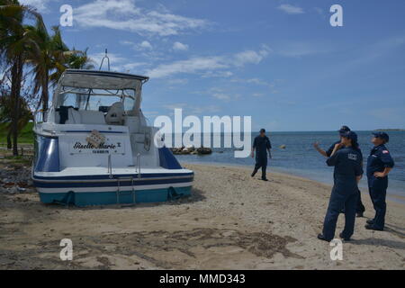 Mitglieder der Maria ESF-10 PR Unified Command Umfrage eine geerdete Boot am Ponce Yacht und Fishing Club in Ponce, Puerto Rico, Okt. 14, 2017. Die Unified Befehl ist der Abteilung der natürlichen und ökologischen Ressourcen, der U.S. Coast Guard und andere Bundes-, Landes- und lokalen Stellen. Das ESF 10 ist der Rahmen durch die Bundesmittel mit staatlichen Behörden in Reaktion auf tatsächliche oder potenzielle ausgelaufenes Öl oder gefährliche Materialien Pressemitteilungen koordiniert wird. U.S. Coast Guard Foto von Petty Officer 1st Class Timothy Tamargo Stockfoto