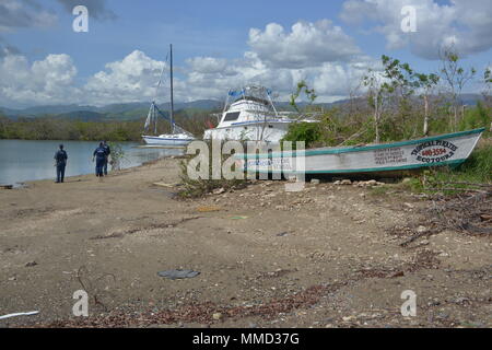 Mitglieder der Maria ESF-10 PR Unified Command Umfrage eine geerdete Boot in Guyama, Puerto Rico, Okt. 14, 2017. Die Unified Befehl ist der Abteilung der natürlichen und ökologischen Ressourcen, der U.S. Coast Guard und andere Bundes-, Landes- und lokalen Stellen. Das ESF 10 ist der Rahmen durch die Bundesmittel mit staatlichen Behörden in Reaktion auf tatsächliche oder potenzielle ausgelaufenes Öl oder gefährliche Materialien Pressemitteilungen koordiniert wird. U.S. Coast Guard Foto von Petty Officer 1st Class Timothy Tamargo Stockfoto