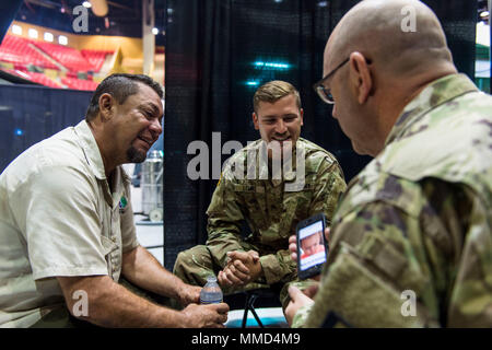 Us-Armee Kapitän Mark Johnston, Chaplin, 14 Combat Support Hospital, Gespräche mit einem lokalen Bewohner, während seine Familie Mitglied wird für eine Kopfverletzung behandelt, als Sgt. Brad Lemky, Behavioral Health, 14. CHS, übersetzt, was Er in Spanisch in Humacao Arena, wo der 14. CHS ihre Feldlazarett in Humacao Puerto Rico, Okt. 18, 2017 Satz sagt. Die 14 CSH ist die lokale Krankenhäuser, deren Fähigkeiten durch den Hurrikan Maria betroffen waren. (U.S. Air Force Foto von Airman 1st Class Nicholas Dutton) Stockfoto
