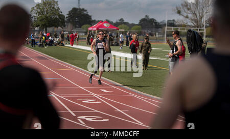 Fellow Athleten anfeuern US Marine Corps Staff Sgt. Jason Pacheco Athlet wie er beendet eine 200-m-Rennen während der 2018 Marine Corps Studien Titel Wettbewerb auf der Marine Corps Base Camp Lejeune, N.C., 20. März 2018. Das Marine Corps Studien fördert die Genesung und Rehabilitation durch adaptive sport Teilnahme und entwickelt die Kameradschaft unter Wiederherstellung-Mitglieder (RSMs) und Veteranen. Es ist eine Gelegenheit für RSMs ihre Leistungen zu zeigen und dient als primärer Schauplatz Marine Corps die Teilnehmer für das DoD Krieger Spiele zu wählen. (U.S. Marine Corps Stockfoto