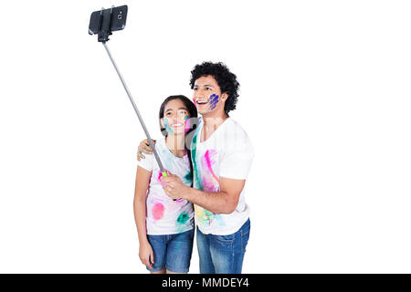 Zwei Teenager Paar Holi Festival unter Selfie Stick Foto Mobile-Phone Stockfoto