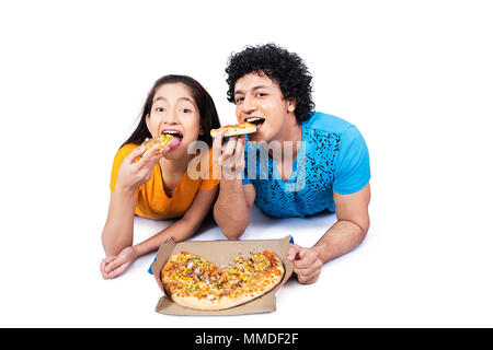 Zwei junge Paar Jungen und Mädchen liegt, Essen Tasty-Pizza Stockfoto