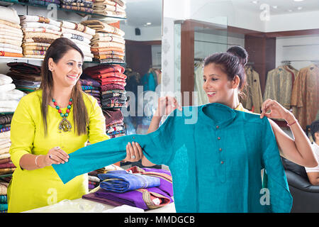 Zwei Damen, die Verkäuferin und die Überprüfung der Kleidung einkaufen Einzelhandel In-Shop Stockfoto