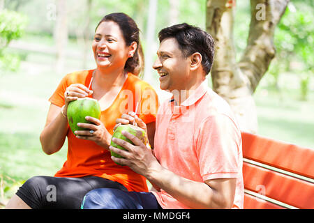 Zwei Paar Sitzbank trinken Kokosnuss Wasser Frische mit Garten Stockfoto
