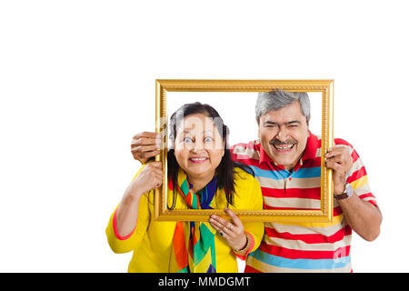 Zwei ältere Paar hält Bilderrahmen über Gesicht Spaß Stockfoto