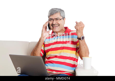 Gerne älterer Mann und Reden Handy mit Laptop Living-Room Vor-Ort-Service Stockfoto