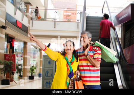 Gerne älteres Paar mit Einkaufstaschen zeigen Shop Shop in-Showroom Stockfoto