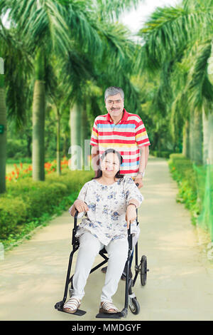 Senior Paar Genießen Sie Ihren Spaziergang In-Park, Frau im Rollstuhl Stockfoto