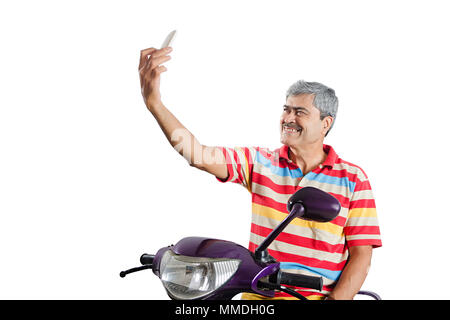 Ein älterer Mann, der Roller unter Selfie Bild auf Cell-Phone Stockfoto