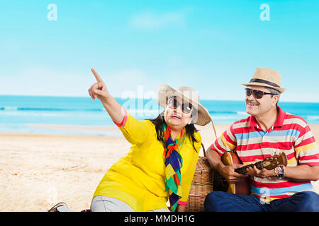 Senior Paar in Liebe mit Picknick - Strand mit Gitarre genießen Stockfoto