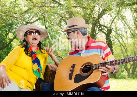 Gerne älteres Paar-dating mit Gitarre auf Picknick im Park Spaß Stockfoto