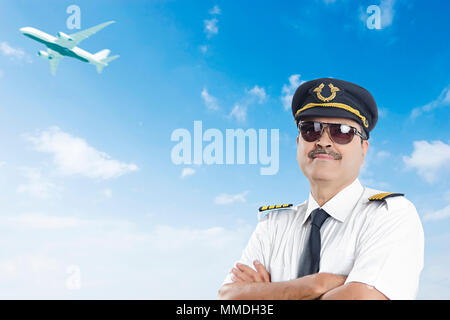 Ein älterer Mann Pilot mit Crossed-Arms ständigen Haltung im Freien Airport Stockfoto