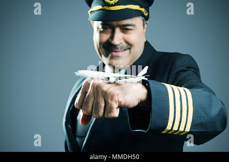 Ein alter Mann Co-pilot mit Dummy Flugzeug auf seiner Hand Stockfoto