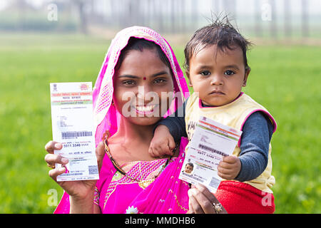 Lächelnd ländlichen Mutter und Kind Sohn zeigen Aadhaar Karte Bauernhof Stockfoto