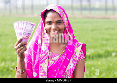 Eine ländliche Dorfbewohner Weiblichen zeigen Indischer Banknoten speichern Farm Stockfoto