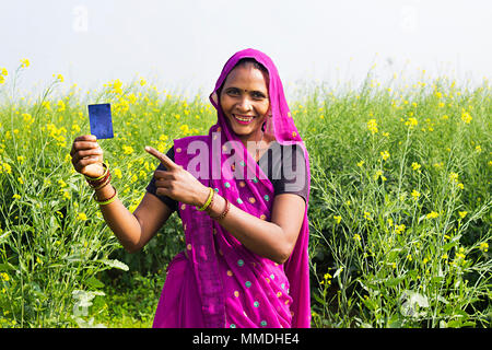 Lächelnd eine ländliche Dorfbewohner Frau zeigt Übersicht Debit-Card Feld Dorf Stockfoto