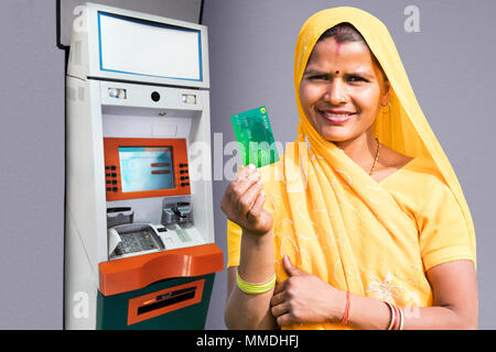 Eine ländliche Dorfbewohner Frau Geld abheben von credit-card bei Cash-machine Stockfoto