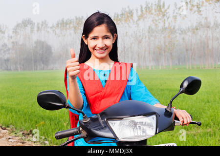 Ländliche junges Mädchen sitzen Roller und Zeige Thumbs-up Farm Village Stockfoto