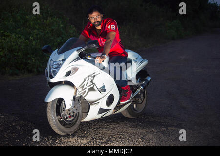 Junger Mann im roten T-Shirt mit einem weißen leistungsstarke Motorrad Stockfoto